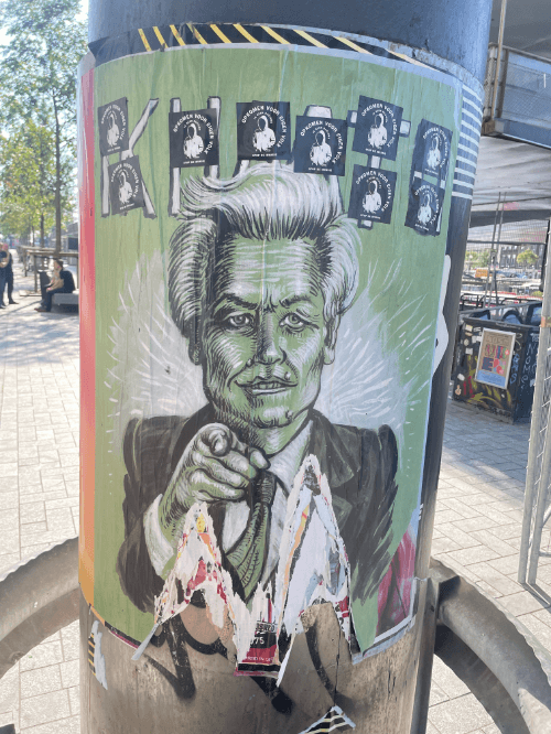 geplakte stickers van een nederlandse vlag op een rerclame bord